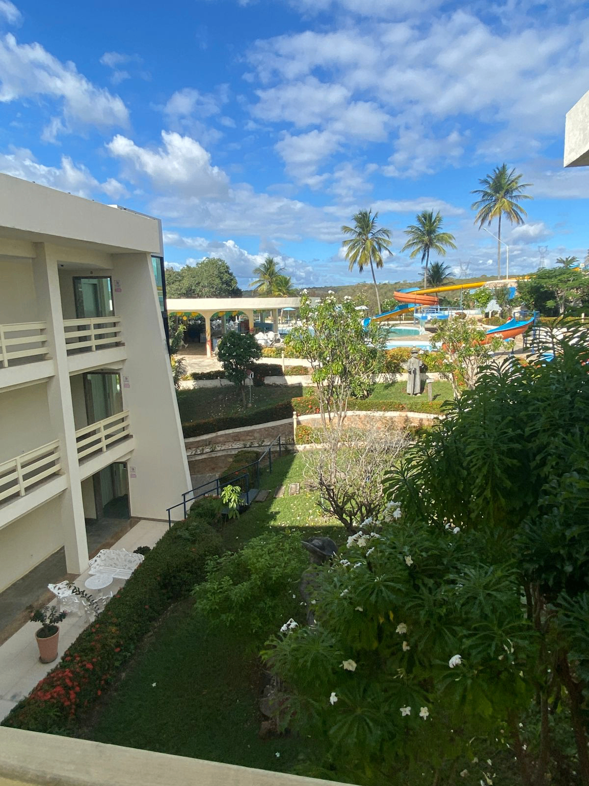 Área externa do hotel com piscina e jardins